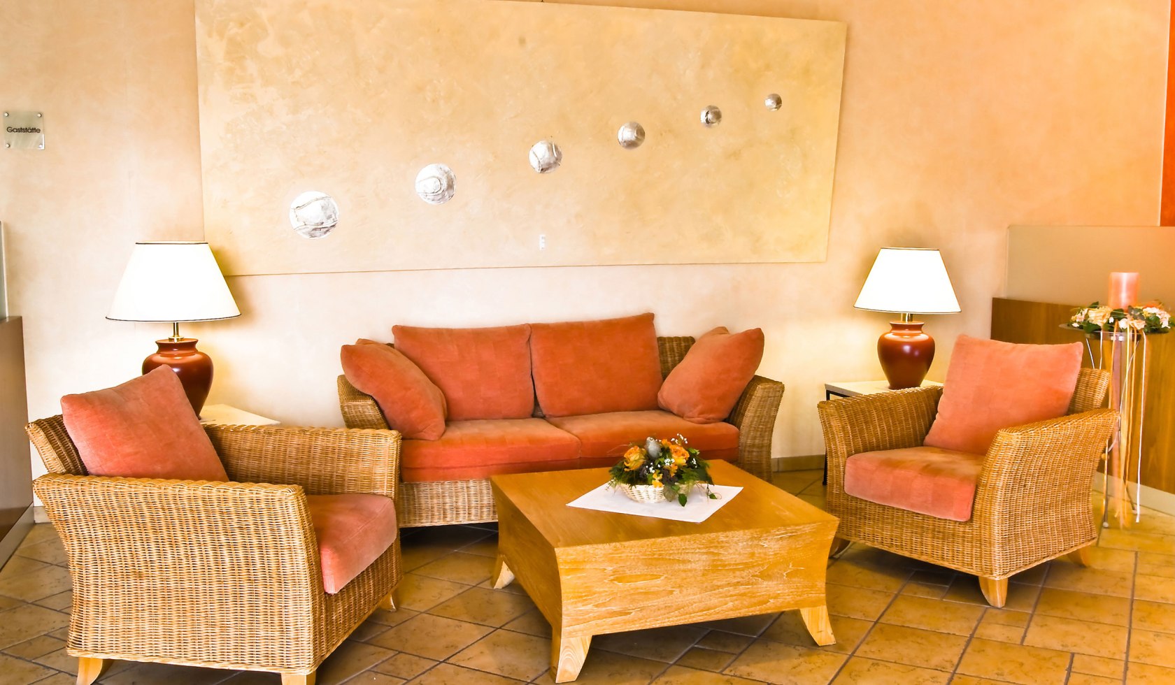 Hotellobby mit Sitzmöglichkeiten in Orangetönen, © laVital Sport- & Wellnesshotel