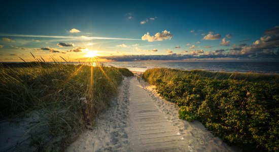 Blick von einer Düne in die untergehende Sonne am Strand von Langeoog, © Tourismus-Service Langeoog/ Andreas Falk