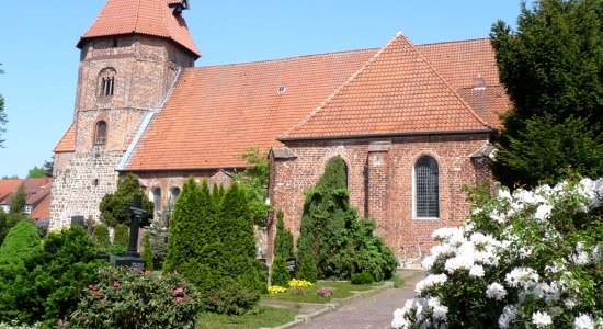 Die St. Laurentius-Kirche in Achim hinter dem schönen Garten mit den blühenden Blumen., © Mittelweser-Touristik GmbH