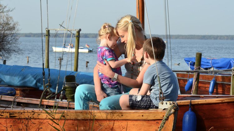 Eine Mutter sitzt mit ihrem Sohn und ihrer Tochter in einem Boot., © Elischeba Wilde