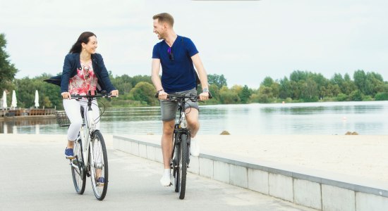 Zwei Radfahrer fahren auf der Promenade am Allersee Rad., © Wolfsburg AG / Jenko Sternberg