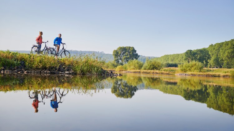 Paar mit Fahrrädern macht Pause an der Weser, © DZT/Jens Wegener