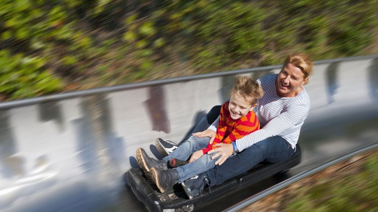 Frau und Junge auf der Sommerrodelbahn im Spielpark Wingst, © Tourismus GmbH Wingst/ Bernd Otten