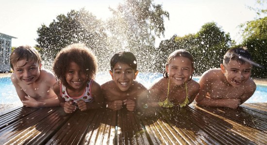 Fünf Kinder planschen am Rand eines Schwimmbeckens., © Stadt Zeven / shutterstock.com