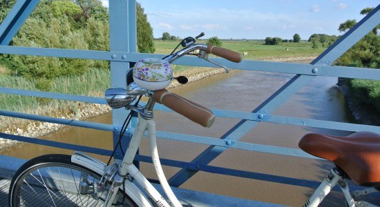 Blick von der Amdorfbrücke im Vordergrund ein Fahrrad, © Ostfriesland Tourismus GmbH / www.ostfriesland.de