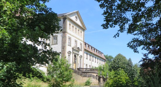 Schloss Ringelheim hinter grünen Bäumen und spiegelndem Wasser., © Nördliches Harzvorland / Anja Gabriel