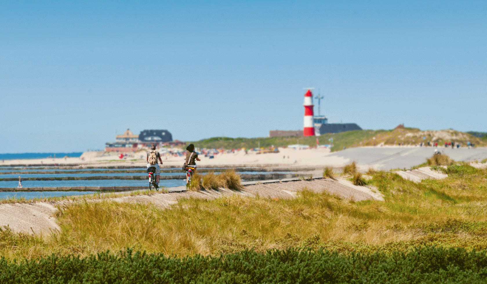 Zwei Radfahrer fahren auf ihren Fahrrädern entlang der Nordsee auf Borkum., © Int. Dollard Route e.V. / Gerd Kaja