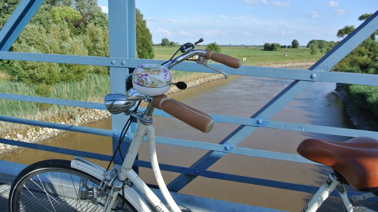 Blick von der Amdorfbrücke im Vordergrund ein Fahrrad, © Ostfriesland Tourismus GmbH / www.ostfriesland.de