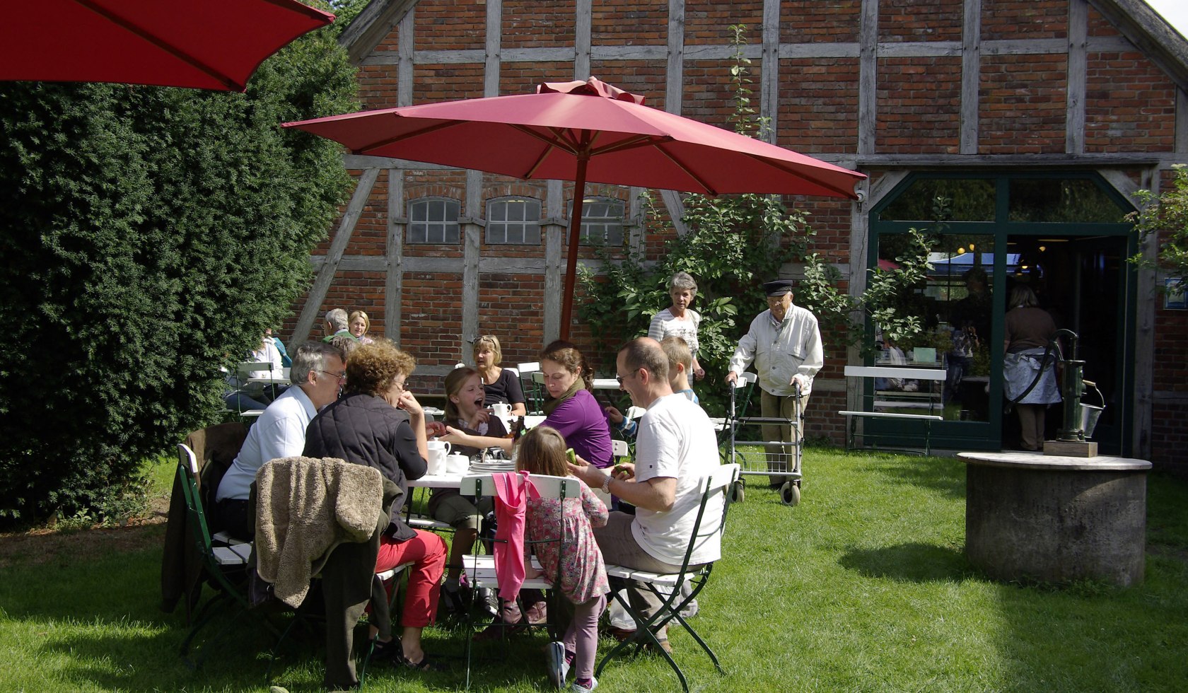 Verschiedene Personen sitzen an einemm Tisch und trinken Kaffee, © Stiftung Freilichtmuseum am Kiekeberg