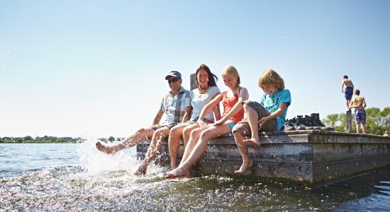 Familie sitzt auf einem Steg am Lohner Freizeitsee, © Grafschaft Bentheim Tourismus e.V./ Schubert