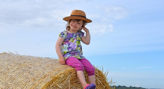 Mädchen auf Heuballen, © Fotolia