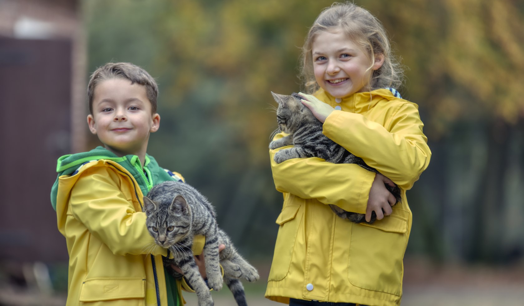 Kleiner Junge und kleines Mädchen mit Katzen auf dem Arm lächeln in die Kamera, © TourismusMarketing Niedersachsen GmbH / Christian Bierwagen