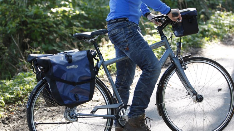 Radfahrer mit zwei Packtaschen am Fahrrad, © TMN / Peter Hamel