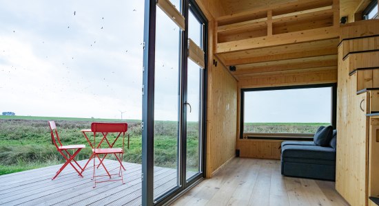 Wohnzimmer und Terrasse des Tiny Houses Harlesiel, © TourismusMarketing Niedersachsen GmbH