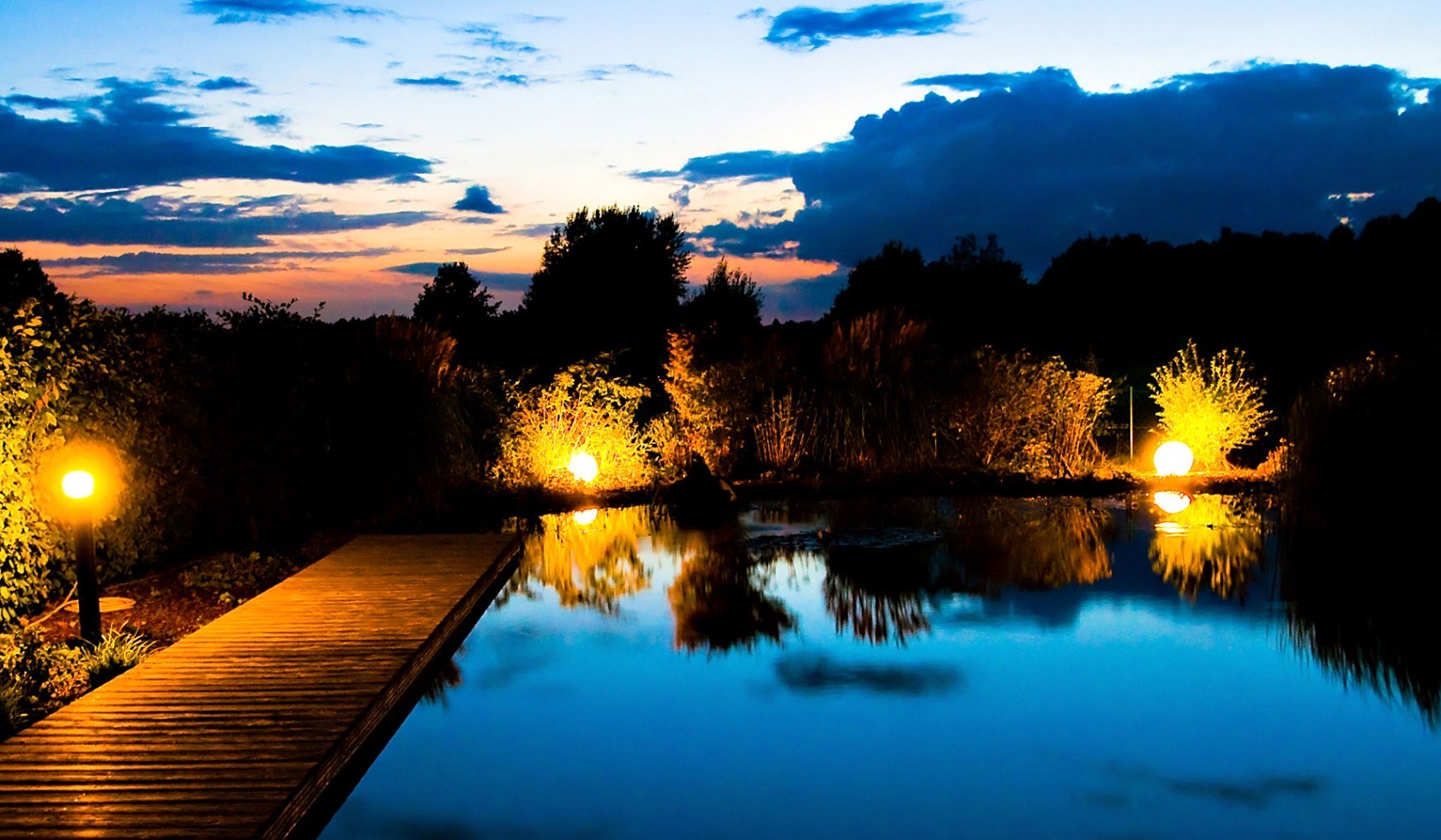 Ein Teich mit Landschaft im Hintergrund im abendlichen Licht, © laVital Sport- & Wellnesshotel