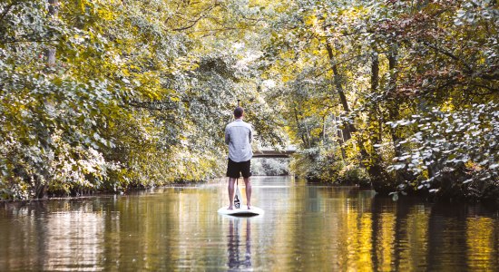 Mann steht auf einem Stand Up Paddle